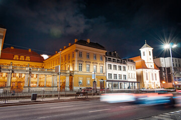 Night in the city. The streets, illuminated by the soft glow of streetlamps.