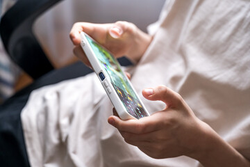 Teenager Immersed in Mobile Gaming on Smartphone