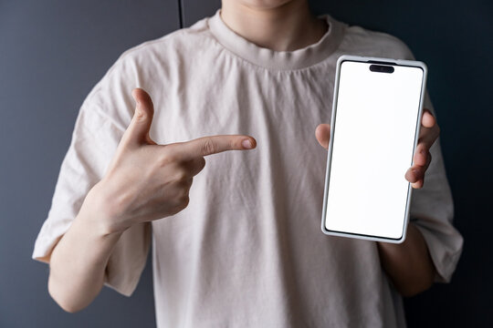Teen Pointing at Smartphone with Blank Screen for Gaming App