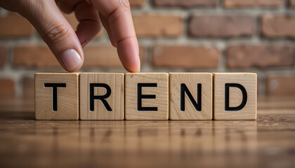 Trendy Concept - Hand Placing Wooden Blocks to Form "TREND" Word on Wooden Surface