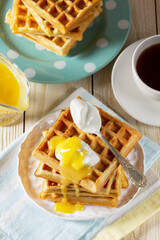 Belgian waffles with cream and lemon curd, served with tea.