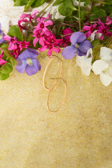 Gold Hoop Earrings with Colorful Flowers on Yellow Textured Surface
