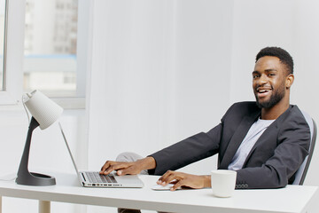Businessman working diligently at desk with laptop and coffee cup in professional office environment