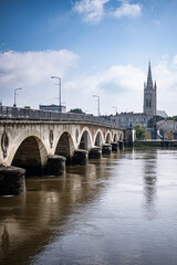 L'église Saint Jean devant le pont de pierre sur la Dordogne à Libourne France en mode portrait