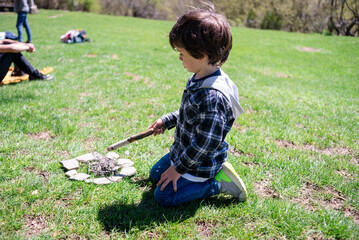 Child explores nature while building a small fire
