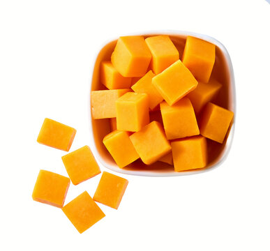 white ceramic bowl with cubes of red cheddar cheese isolated on a white background, top view.