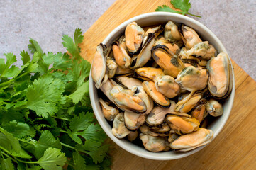 Cleaned boiled mussels in a bowl on a dark background, horizontal