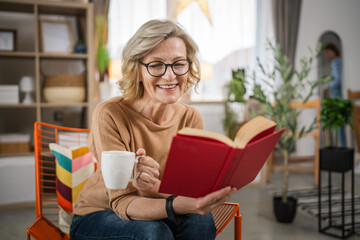 One woman mature caucasian female read book at home wear eyeglasses