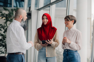 Business people discussing using tablet in modern office