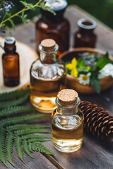 Bottles of tincture or potion, organic essential oils, dry healthy herbs, floral extracts on wooden table. Pure natural ingredients for cosmetic production. Concept of alternative herbal medicine