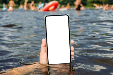 Close-up, mockup of a smartphone in water in a man's hand. Against the backdrop of people swimming. Time for rest and travel.