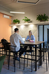 Colleagues collaborating in a stylish setting with plants and modern decor