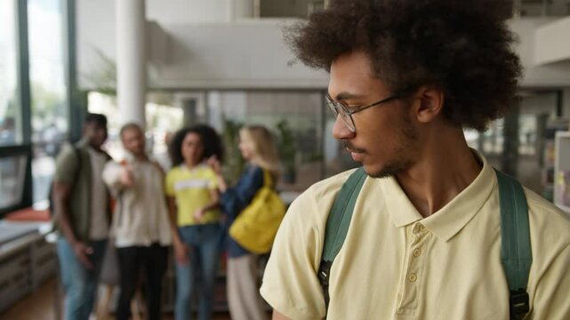 African American man guy male student suffering offended sad with mockery laughing pointing fingers envy classmates students discrimination bullying in high school university college lonely racism