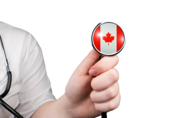 The head of a medical stethoscope in the shape of the Canadian flag in a hand (close-up) on a transparent background. Canada's healthcare system concept