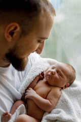 .a candid photo of a father and a newborn baby in their arms in the maternity ward. Selective...