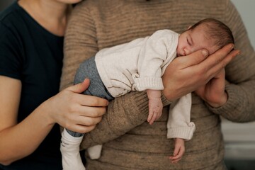 Newborn Baby Sleeping in Parent's Arms