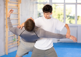 Father teaching his son wrestling or self-defense techniques in the gym