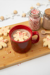 Hot Chocolate in a Red Cup with Snowflake-Shaped Marshmallows with Jars of Peppermint Candy and Hot Chocolate in Background
