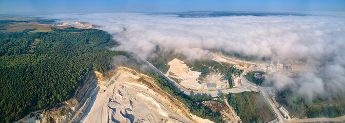 Aerial view of open pit mining of limestone materials for construction industry with excavators and...