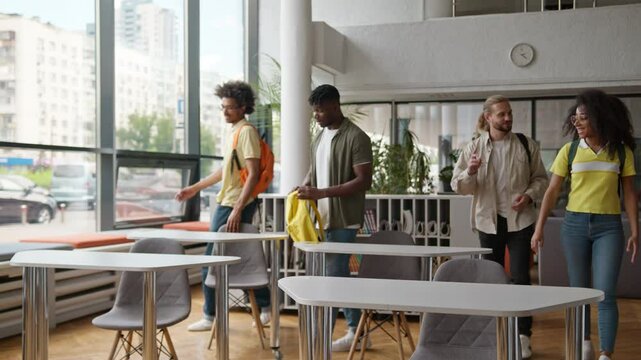 Four multiracial students multiethnic Caucasian diversity friends African American classmates come in university school college classroom in morning talking start studying day lesson learning class