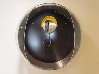 Vintage Payphone in Circular Enclosure: Nostalgic Public Telephone