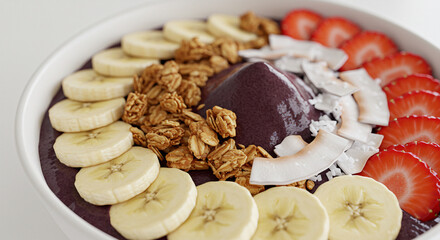 A&ccedil;a&iacute; bowl with fruits and granola, close-up, tropical summer feel, white clean background.