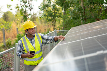 Solar Panel Inspection: A dedicated worker, clad in a yellow safety helmet and vest, meticulously...