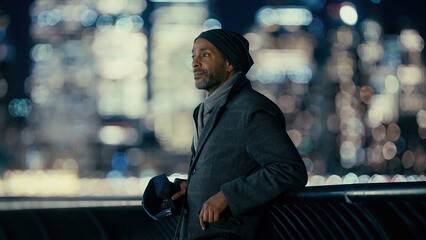 Businessman looking at the illuminated Manhattan skyline at night, New York, USA