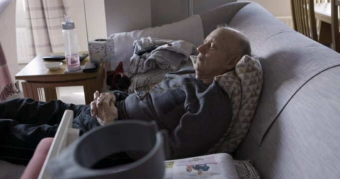 Retirement, sleeping and senior man on sofa to relax, tired and retired with peace, on couch and in living room. Rehabilitation, elderly man and rest in home, being peaceful, napping and in lounge.