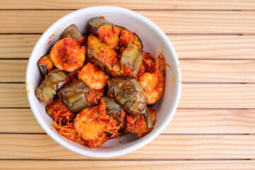 Overhead View of Shrimp and Eggplant Stir fry in a White Bowl on a Wooden Table