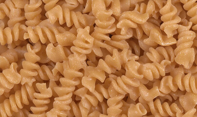 Close-up of cooked rotini pasta with spiral grooves, filling the frame with their tight formation