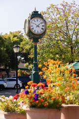 Los Altos, California, USA - August 30, 2024: Morning traffic passes the historic wrought iron clock in the historic downtown district.