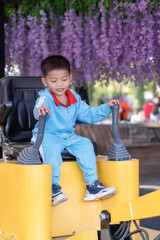 Happy Asian boy playing Children's Playground at the public park with training in operating the excavato stock photo