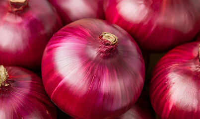 Vibrant red onions piled together, showcasing their rich color and texture, and their bulbous shapes in sharp detail