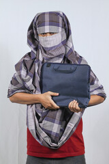 The thief carrying a bag containing the stolen laptop walks carefully out of the house