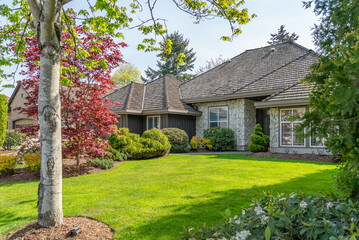 Two story stucco luxury house with nice spring blossom landscape in Vancouver, Canada, North...