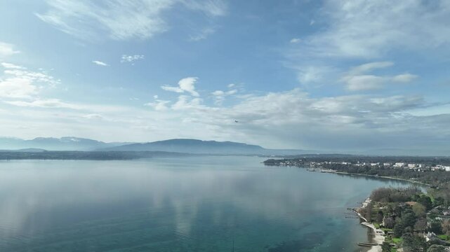 Aerial view of Lake Geneva with a plane landing into GVA