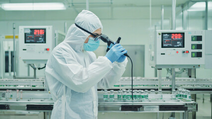 High-tech pharmaceutical laboratory, close-up of a scientist in full PPE using precision instruments to measure active compounds, sterile and futuristic environment.