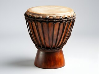 A traditional African djembe drum with a rich brown wooden body and stretched animal skin head sits on a plain background.