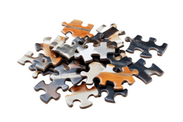 Close-up view of a collection of various-colored jigsaw puzzle pieces, haphazardly clustered together.