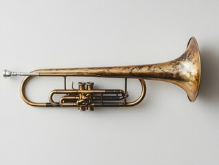 Obraz premium A vintage brass trumpet rests on a plain white background showcasing its aged patina and intricate details.