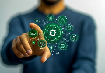 A man in a blue sweatshirt is touching green circular icons with carbon, cloud, and gear symbols floating above his hand