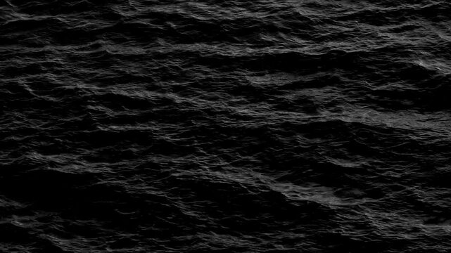 A captivating black and white image of sea waves in motion, where the dynamic flow of the water creates a powerful visual, showcasing the raw energy and beauty of the ocean's movement.
