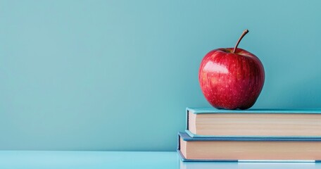Books and pencils topped with an apple, set against a cool glacier blue background for educational promotions Text space on the right