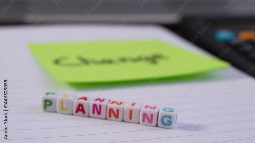Poster close-up of a sticky note with the word change; when you zoom out you can see the word planning in c