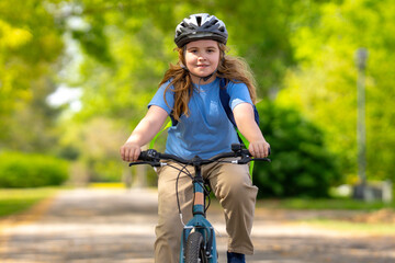 Child bike ride. Teen boy biking down summer road. Kid riding bicycle with smile. Child cycling....