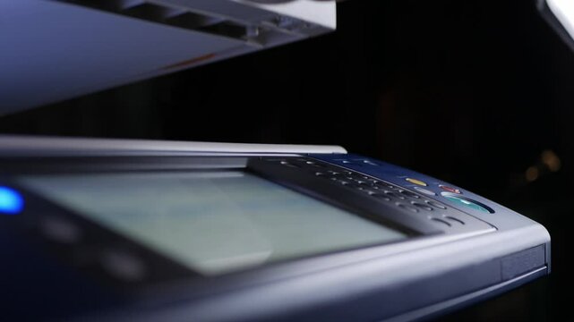 Close up hand office man press start button on panel to using the Office professional multi-function printer scanner for scanning document printing. a Copy machines