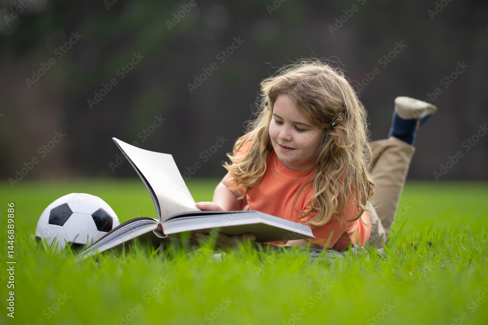 Poster child reading a book in the grass. kid enjoying a book story outdoors. child studying with book in t