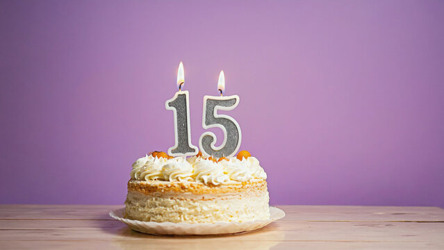Sweet Fifteen Celebration: A delightful cake with two burning candles marks the special occasion of a fifteen-year milestone. The frosted cake and a backdrop of a soft hue create a festive mood.