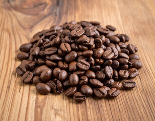 Fototapeta premium Pile of coffee beans on a wooden table